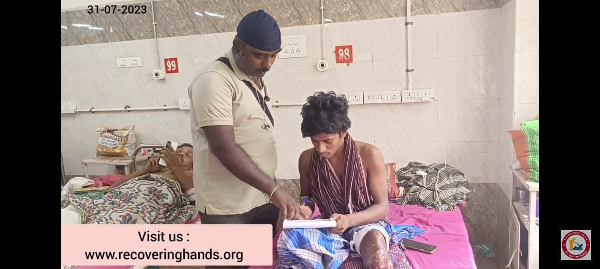 Volunteer writing case notes beside a patient