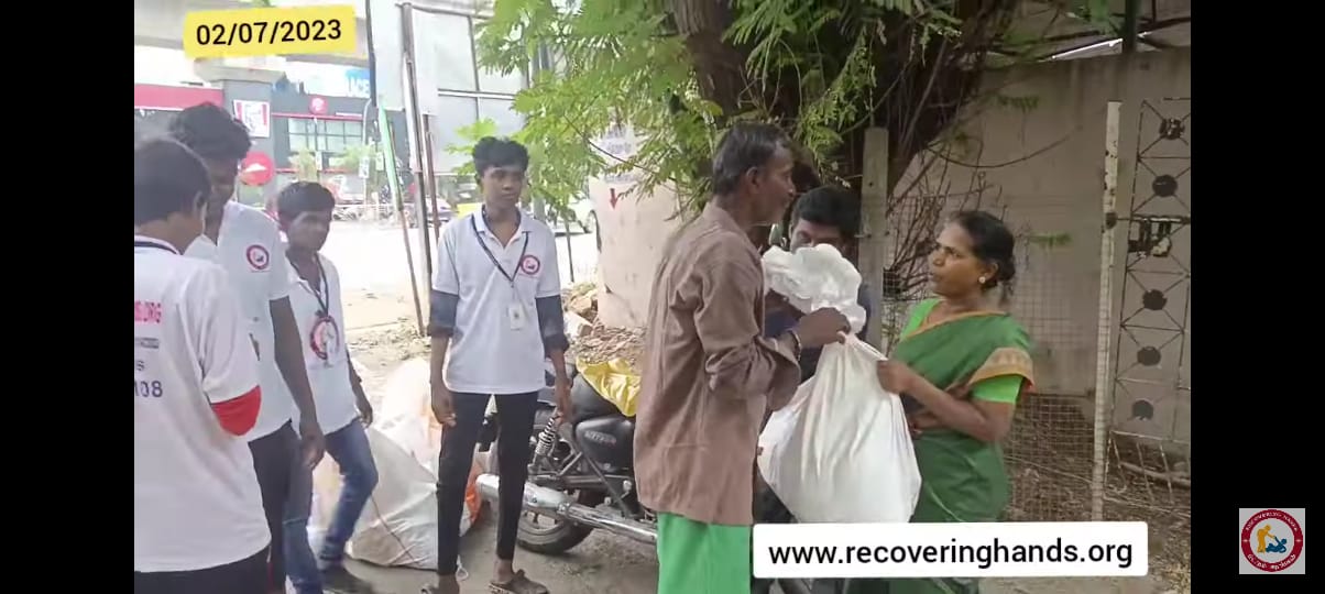 Volunteers handing a bag of groceries to a family