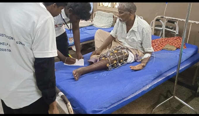 A volunteer registering a patient's details at his hospital bedside